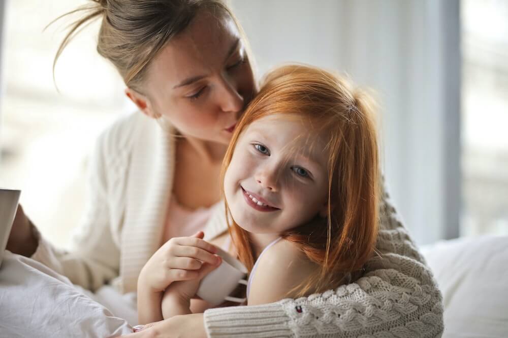 mother kissing daughter | This Time Of Mine