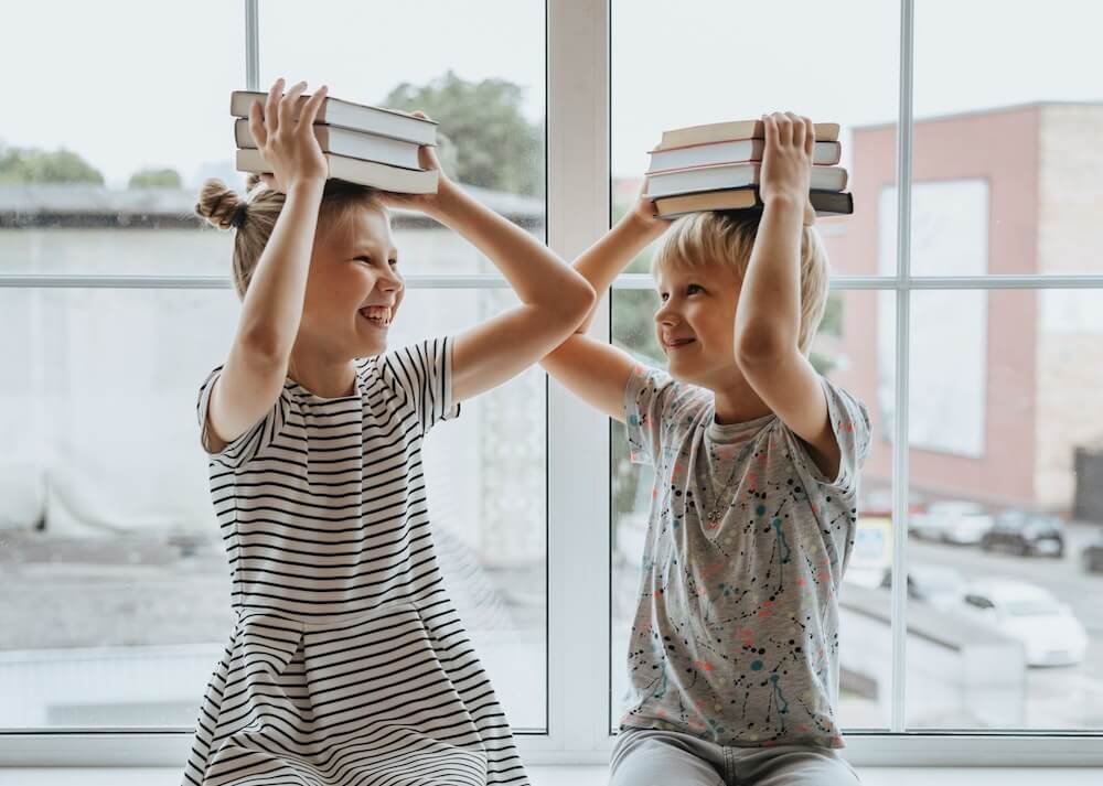 children with books on their heads | This Time Of Mine